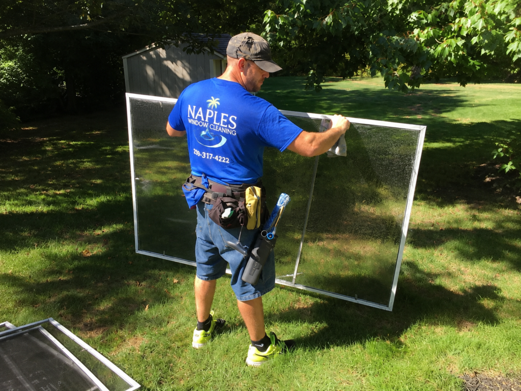 Professional cleaning a large residential window screen