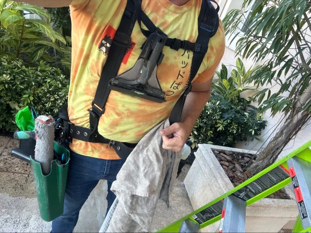 Josh of Naples Window Cleaning LLC wearing professional window cleaning harness with squeegee and bucket